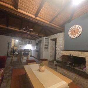 een woonkamer met een klok aan de muur bij Κτήμα Βασίληγιάννη 