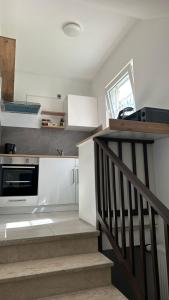 una cucina con mobili bianchi e una scala di Casa Verona a Landstuhl