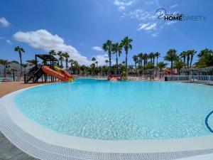 a large swimming pool at a resort with a slide at Oasis Dunas Sweet Family Home II Pool view by B-Rent in Corralejo