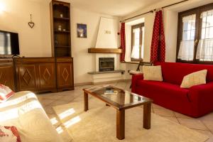 a living room with a red couch and a coffee table at Maison Plan de Dieu in Saint-Pierre