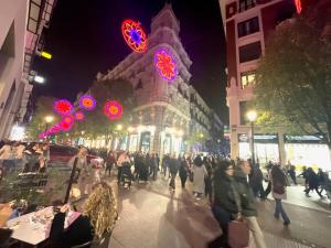 Eine Menschenmenge, die nachts eine Straße entlangläuft. in der Unterkunft Luz Madrid Rooms in Madrid