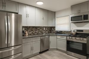 a kitchen with white cabinets and stainless steel appliances at Spacious 4Bdrs house with parking in Hempstead
