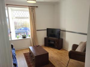 a living room with a tv and a couch and a table at 4 johns terrace in Carmel
