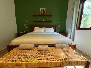 una camera da letto con un letto grande con pareti verdi di Solaya Residence - Boutique Beach-House in Kizimkazi with Garden & Parking 