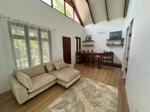 un soggiorno con un divano e un tavolo di Solaya Residence - Boutique Beach-House in Kizimkazi with Garden & Parking 