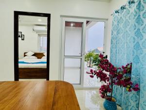 THS Suites - Luxurious 2 BHK AC apartments with Tirumala Views - Near Marriott, Taj and ITC 5 star hotels - Walkable to PS4, A2B, Orion, Starbucks cafes - Close to Thiruchanur and Alipiri flyover في تيروباتي: غرفة مع طاولة وغرفة نوم مع سرير