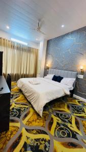 een slaapkamer met een groot bed en een kleurrijk tapijt bij AERON kabila Resort in Sītāpur