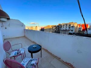 a patio with chairs and a table on a balcony at 2 BR apartment - City Center Residency - Panoramic City Views - 3 Min Train Access by ZenStay in Fès