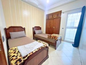 a room with two beds in a room with a window at 2 BR apartment - City Center Residency - Panoramic City Views - 3 Min Train Access by ZenStay in Fès