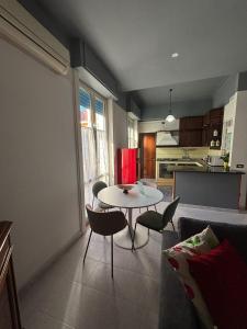 a living room with a table and chairs and a kitchen at LillaBloom in Nocera Inferiore