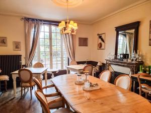 a dining room with tables and chairs and a chandelier at Chambres d'Hotes Le 1900 in Val Couesnon
