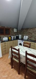 a kitchen with a table and two chairs and a stove at Ferradosa GuestHouse in São João da Pesqueira