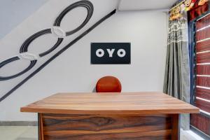 a wooden table with a chair next to a wall at Hotel O Shubh Residency in Bhundsi