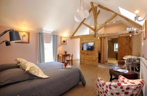 a bedroom with a large bed and a living room at La villa des Chouettes in Maisons-lès-Chaource