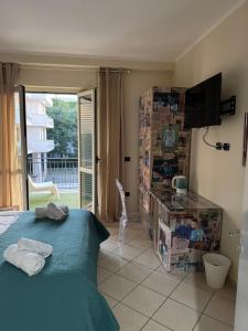 ein Schlafzimmer mit Bett, Fernseher und Balkon in der Unterkunft IM 10 affittacamere in Cimitile