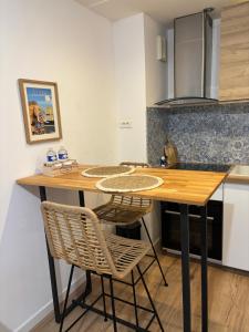 Una cocina con una mesa y sillas de madera. en Maison cocooning, en Saint-Sébastien-sur-Loire 6 fotos más