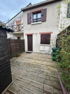 una casa con una terraza de madera frente a ella en Maison cocooning, en Saint-Sébastien-sur-Loire
