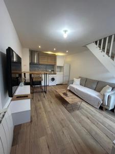 una sala de estar con un sofá y una mesa en Maison cocooning, en Saint-Sébastien-sur-Loire