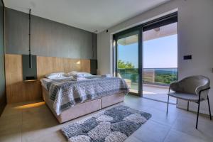 een slaapkamer met een bed, een stoel en een raam bij Villa Bella in Bale +59 foto's