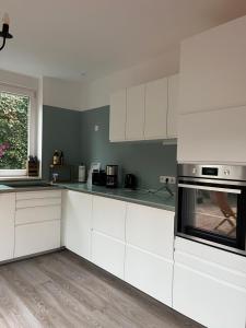 a white kitchen with white cabinets and appliances at Family-friendly accommodation in Seesen +8 photos