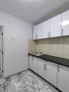 an empty kitchen with white cabinets and a sink at Apartament cu 1 camera in Soroca
