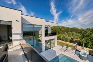 een glazen huis met een zwembad en een patio bij Villa Bella in Bale