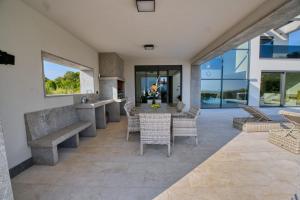 een patio met een tafel, stoelen en ramen bij Villa Bella in Bale