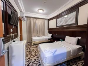 a hotel room with two beds and a television at فندق مهوى الفؤاد - المعابدة in An Naqāʼ