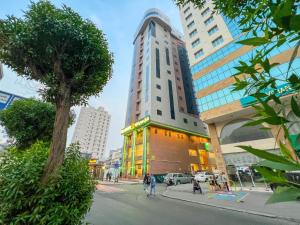 a tall building in a city with people walking on the street at فندق مهوى الفؤاد - المعابدة in An Naqāʼ