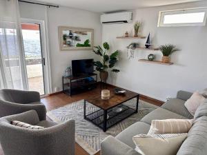 a living room with a couch and chairs and a table at Casa Beira Mar in Angra do Heroísmo