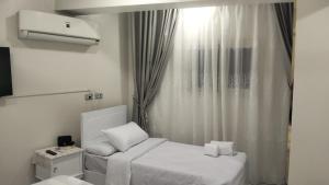 a small room with a bed and a window at Aswan Key Cozy in Nag` el-Ramla