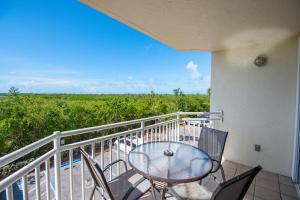 ein Balkon mit Tisch und Stühlen und Aussicht in der Unterkunft The Cayo Coco | Key West Condo with Pool Hot Tub & Balcony Views in Key West