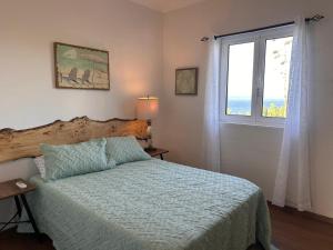 een slaapkamer met een bed en een raam bij Casa Beira Mar in Angra do Heroísmo