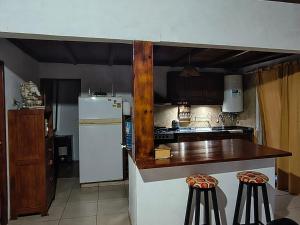 a kitchen with a white refrigerator and a counter at Casa con Gran Patio in Villa Parque Siquiman +1 photo