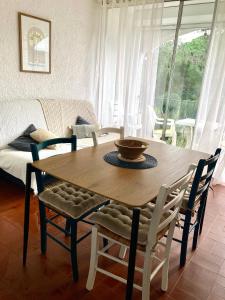 a wooden table and chairs in a living room at Idyllique ! Terrasse vue jardin et montagne, parking, local à vélos, à 2 pas de la plage et piscine de mai à septembre ! in Argelès-sur-Mer +40 photos