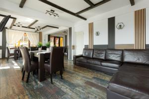 ein Wohnzimmer mit einem Tisch und Ledermöbeln in der Unterkunft Popasul de Wis in Moieciu de Jos