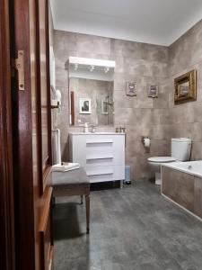 a bathroom with a sink and a tub and a toilet at Casa de Lorca in Alcalá de Henares