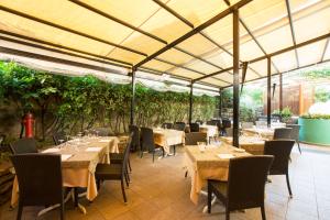 a restaurant with tables and chairs and vines at Albergo Giardino in Cernobbio