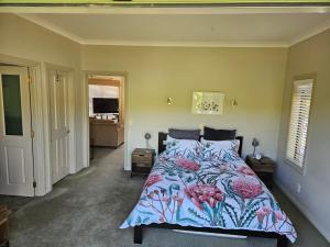 a bedroom with a bed with a colorful comforter at Ridgetop cottage in Wairakei