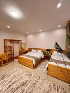 Un dormitorio con dos camas y una alfombra. en Deluxe experience siwa, en ‘Izbat Ţanāţī