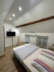 een slaapkamer met twee bedden en een flatscreen-tv bij Maison le petit coin secret in Châtillon-sur-Seine