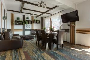 ein Esszimmer mit einem Tisch und Stühlen sowie einem Flachbild-TV in der Unterkunft Popasul de Wis in Moieciu de Jos