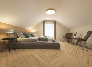 a bedroom with a bed and two chairs and a window at Aqua & Wellness resort Alzbeta in Liptovský Mikuláš