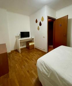 The Mazzitellis Home في نيتّونو: غرفة نوم بها سرير ومكتب مع تلفزيون