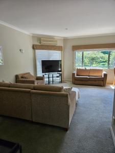 a living room with two couches and a television at Ridgetop cottage in Wairakei