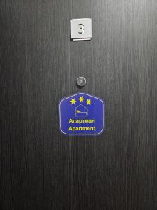 a door with a blue sign on it at Apartman Mir in Temerin