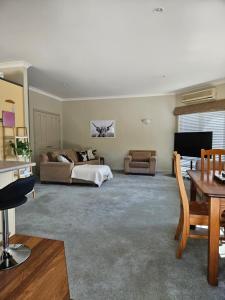 a living room with a bed and a couch at Ridgetop cottage in Wairakei