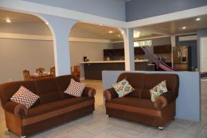 two brown leather couches in a living room at Costabay in El Zapote