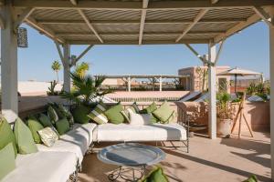 a patio with green and white couches and a table at Dar Lalla F'dila in Marrakesh