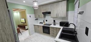 Mountain Ridge Lux Stay في روستنبرج: مطبخ بجدران بيضاء وأخضر وخزانات خشبية +9 صور